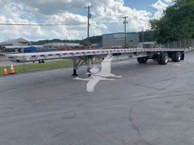 Reitnouer CK-100 flatbed trailer in side view showing long steel deck, tandem axles, and support legs.