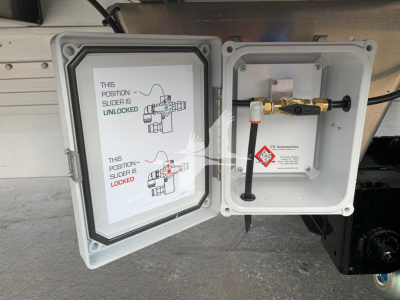 Trailer hitch area showing a CNF electrical box and a valve with a white label. The left door shows a diagram with green and red text about position slider unlocked/locked.