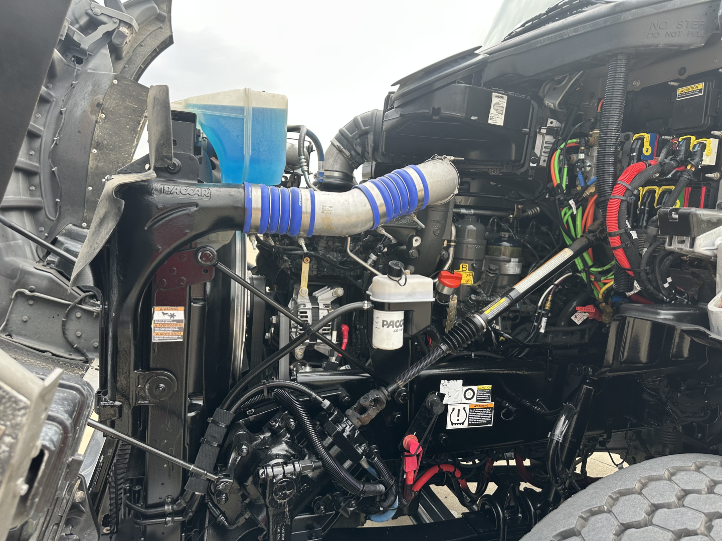 Kenworth T880 engine bay showing various hoses, wiring, and filters.