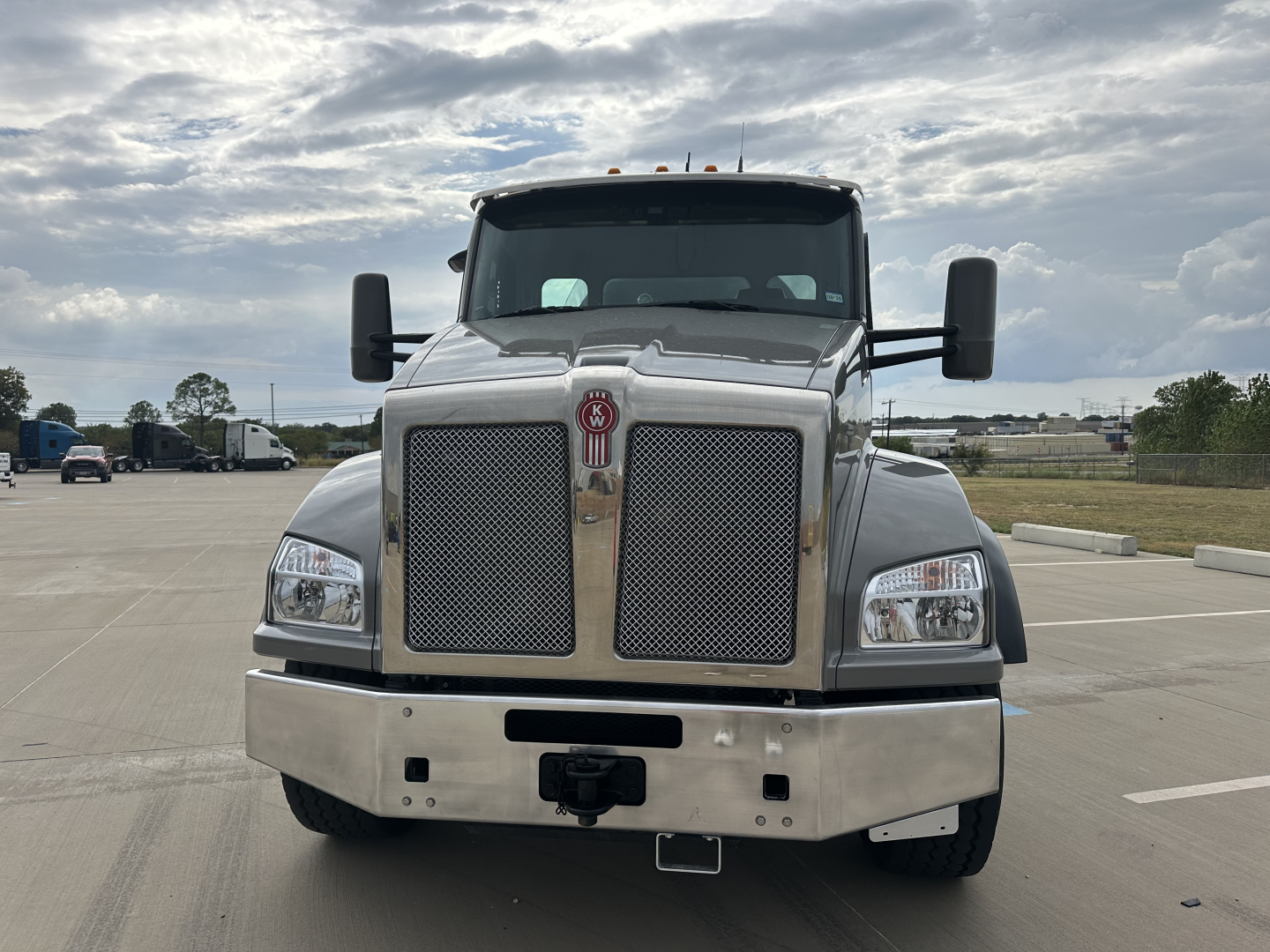 Front view of a Kenworth T880 mixer truck showing large chrome grille, dual mirrors, and heavy-duty bumper.