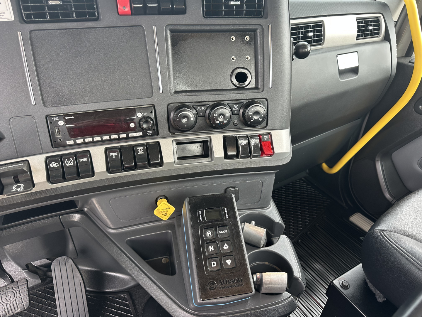 Kenworth T880 truck interior dashboard and center console with switches, knobs, and gear selector in view.