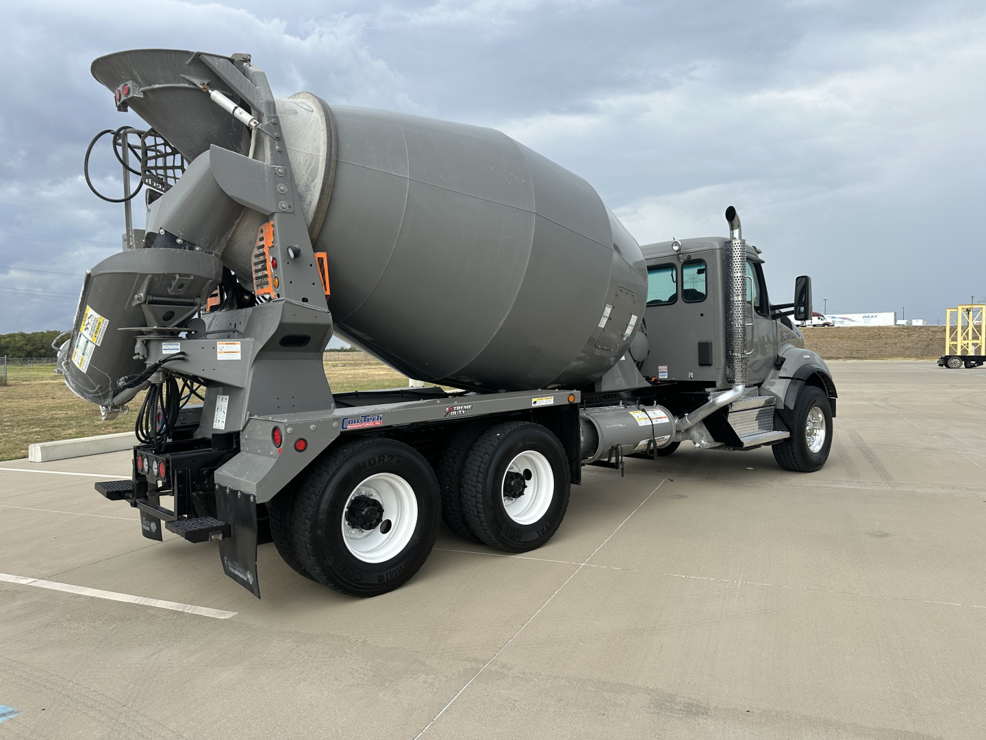 Kenworth T880 mixer truck rear-right view showing concrete mixer drum and chute assembly.