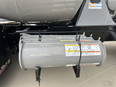 Kenworth T880 mixer truck undercarriage showing cylindrical fuel tank with warning labels and mounting brackets.