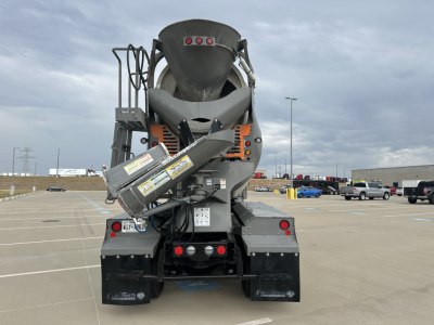 Kenworth T880 mixer truck rear view showing cement mixer chute and warning labels