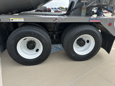 Dual rear wheels on a mixer truck showing Continental tires and white rims next to a metal frame with Extreme Duty