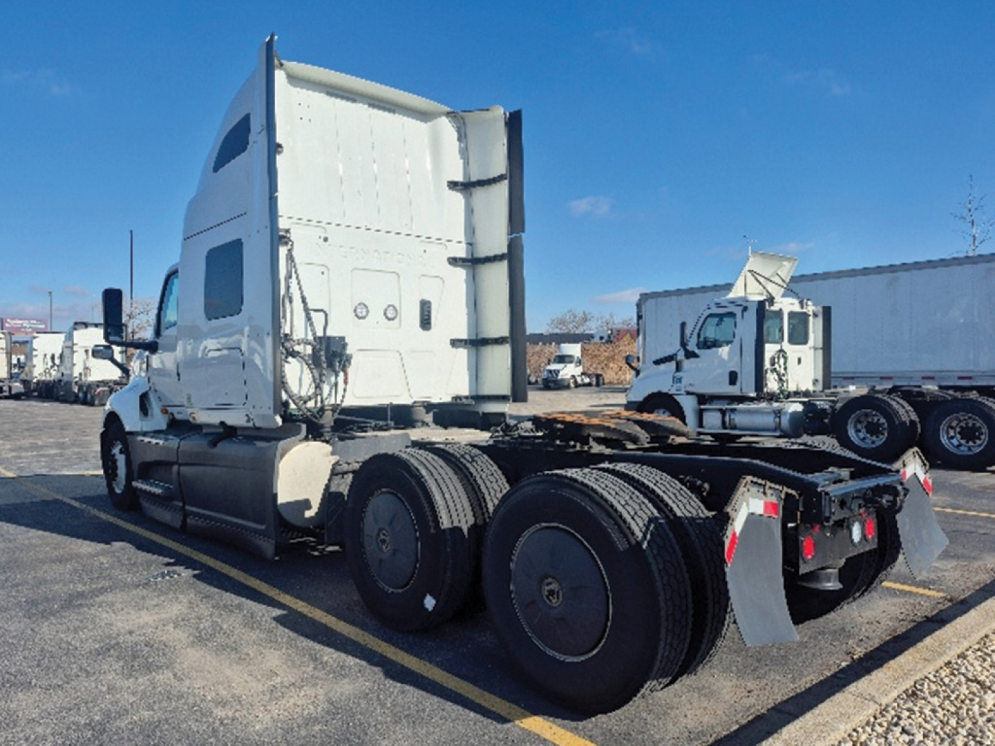 International LT625 truck tractor rear view showing dual rear axles and fifth wheel, white cab, fuel tanks, and trailer connections visible.