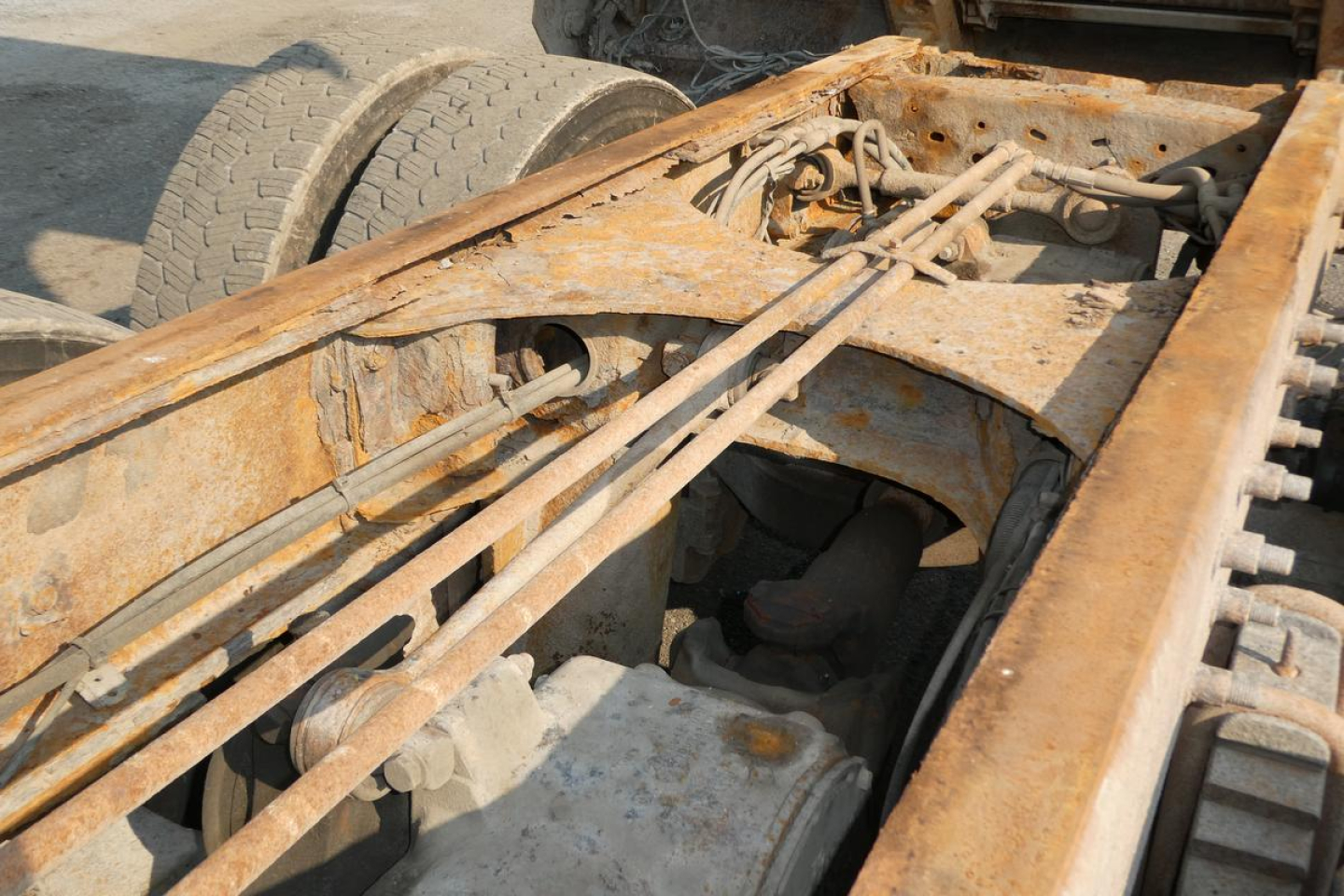 Mack GU713 chassis with rusted frame and exposed hydraulic lines.
