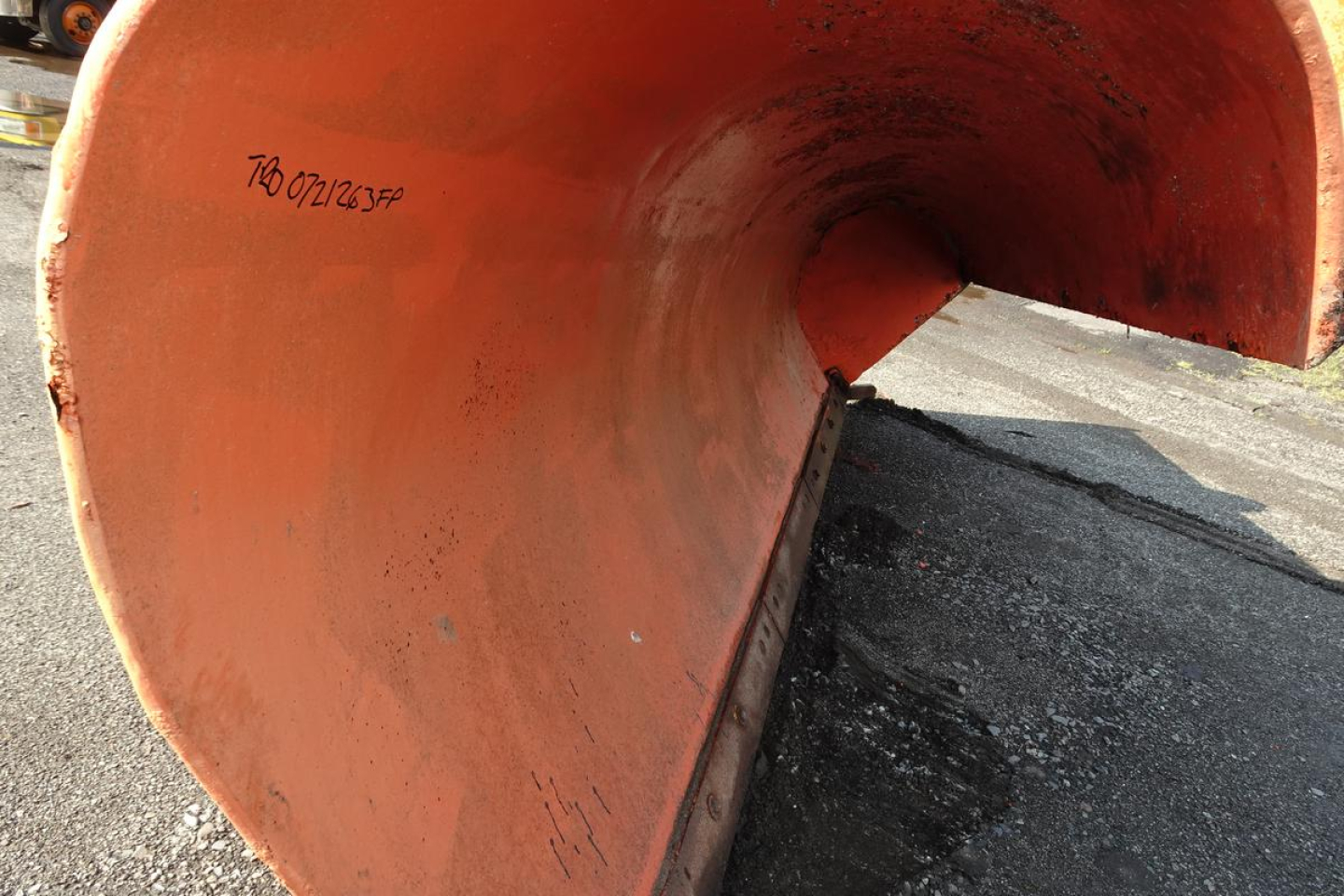 Mack GU713 dump truck component showing orange interior of a large pipe or chute.