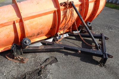 Mack GU713 dump truck chassis hitch with orange snow plow blade and chain ties, front lower view