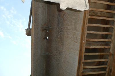 Mack GU713 dump truck bed side with rust and ladder rungs visible