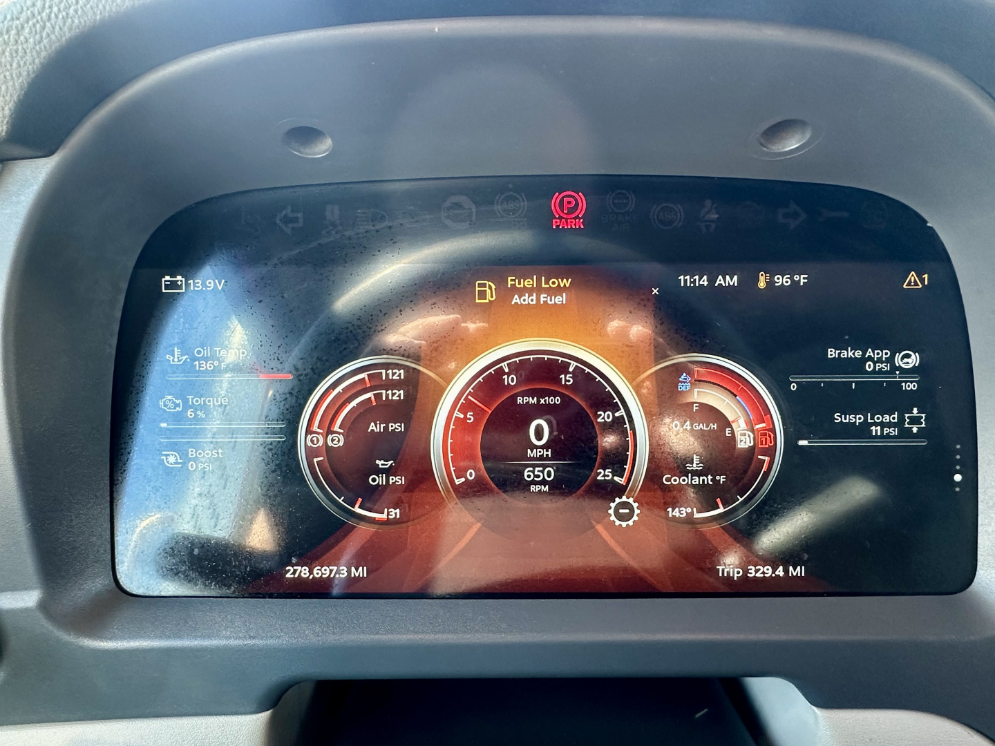 Peterbilt 567 dashboard cluster displaying digital gauges and warning icons; fuel low alert, RPM and speedometer at center, odometer/Trip data visible.