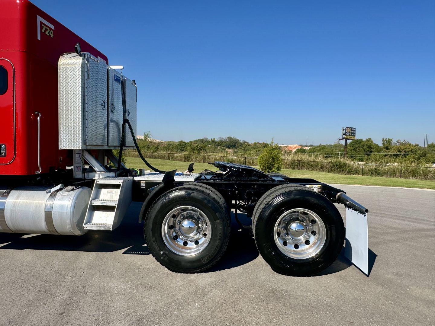 Peterbilt 567 truck chassis with dual rear tires and semi-truck fuel tank visible, side view showing fifth wheel area and rear axle.