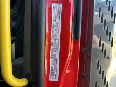 Vehicle information label on Peterbilt truck door frame showing tire and weight data and barcodes.