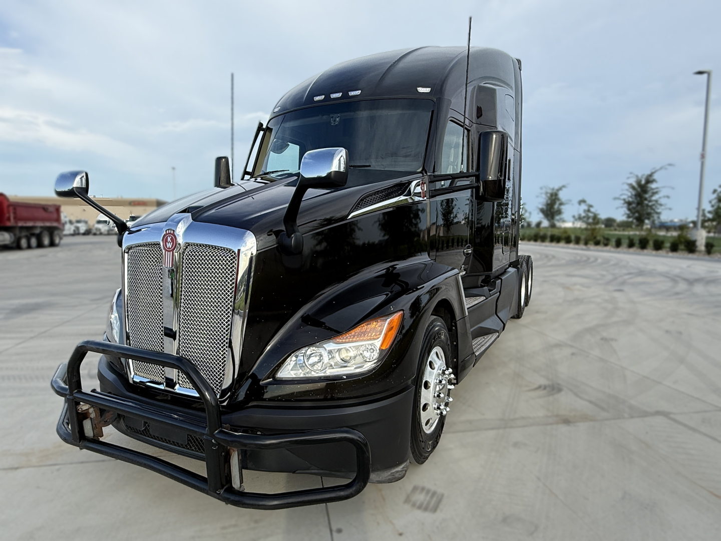 Kenworth T680 tractor cab front view showing chrome grille and bumper guard.