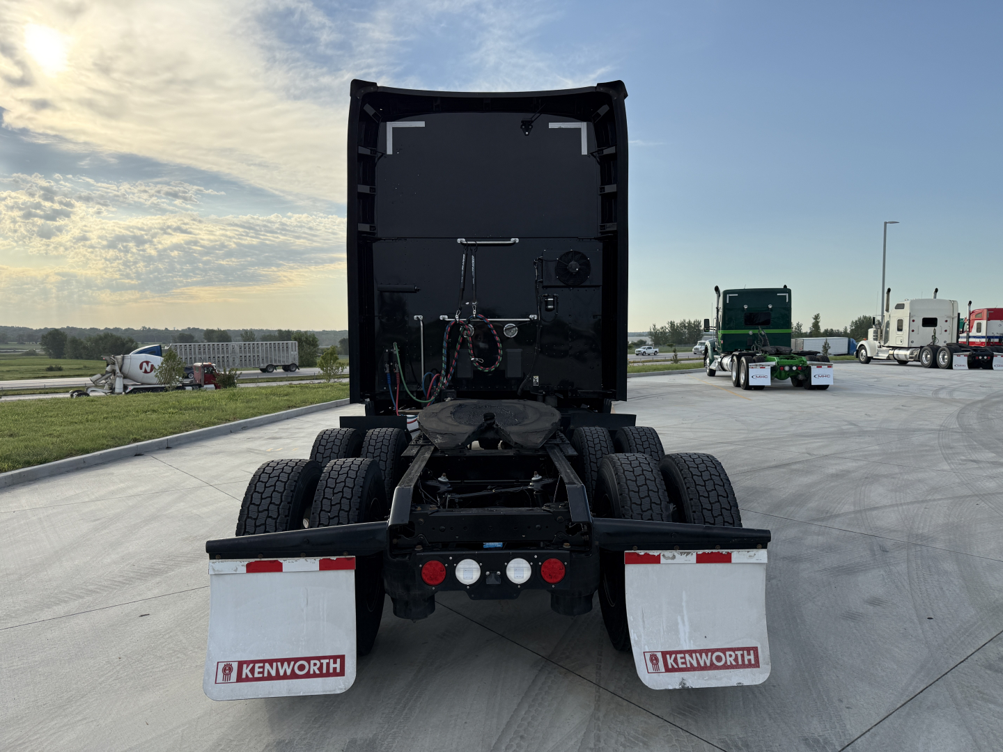 Kenworth T680 rear view showing fifth-wheel, dual rear axles, and mud flaps.