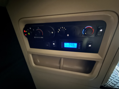 Dash of a 2023 Kenworth T680 showing climate controls, digital display, and gauge cluster in the instrument panel.