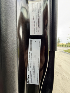 Kenworth T680 door jamb showing identification stickers with VIN, stock number, and model details.