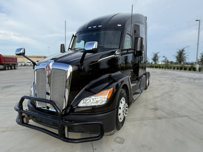 Kenworth T680 tractor cab front view showing chrome grille and bumper guard.