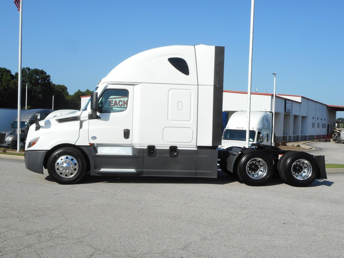 Freightliner Cascadia 126 tractor side view showing sleeper cab and long wheelbase, white exterior, dual rear axles.