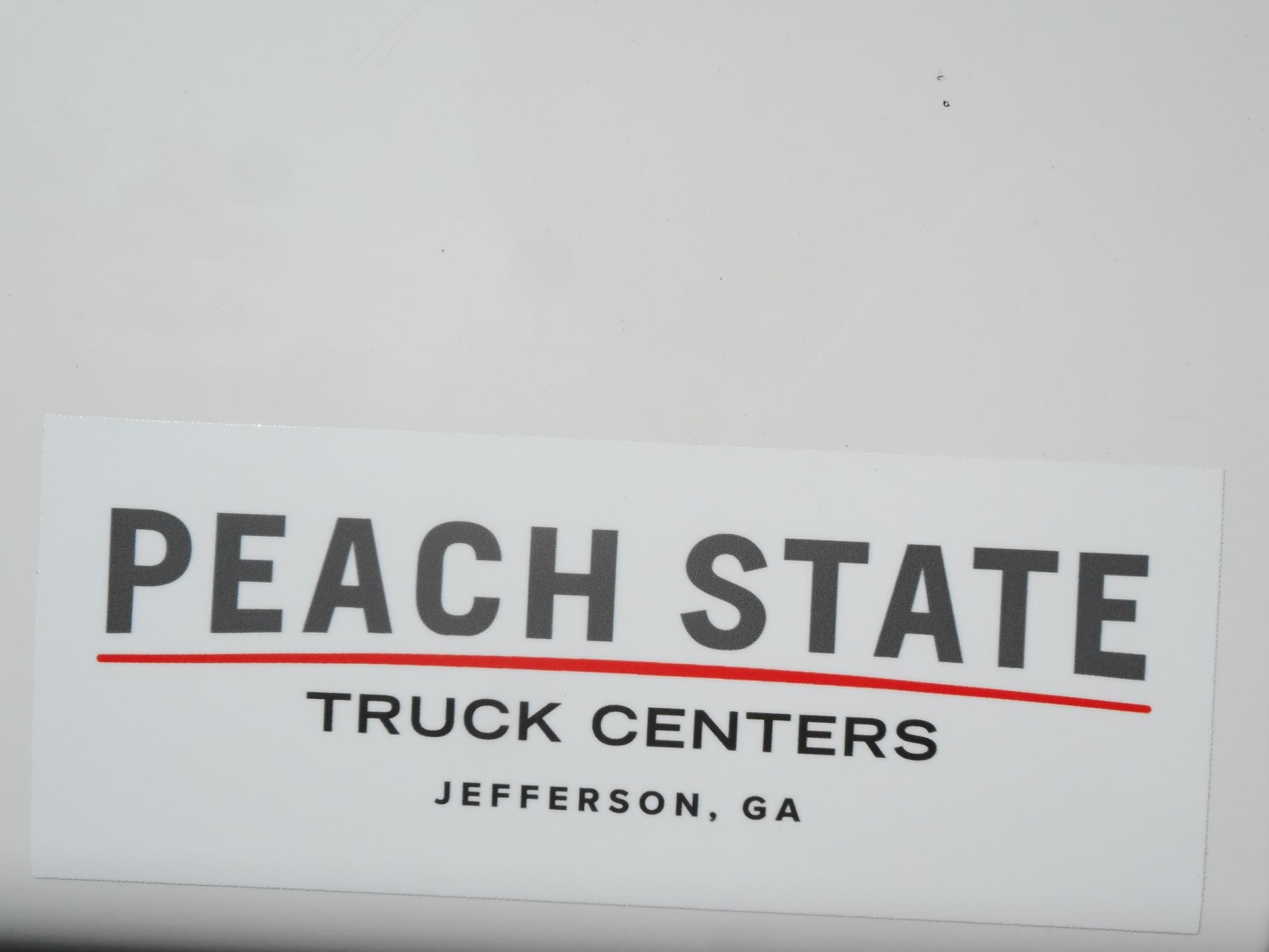 Freightliner Cascadia truck center sign in image with Peach State Truck Centers logo
