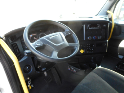 Truck cab interior showing steering wheel, dashboard, and center console of a Freightliner Cascadia 126.