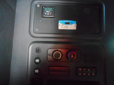 Cab controls panel of a Freightliner Cascadia showing ignition switch, climate controls, and auxiliary switches.