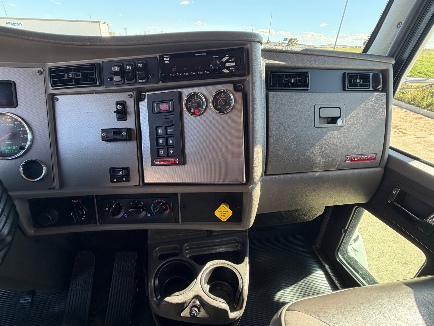 Kenworth T270 dashboard and driver area showing gauges, control switches, and cup holders.