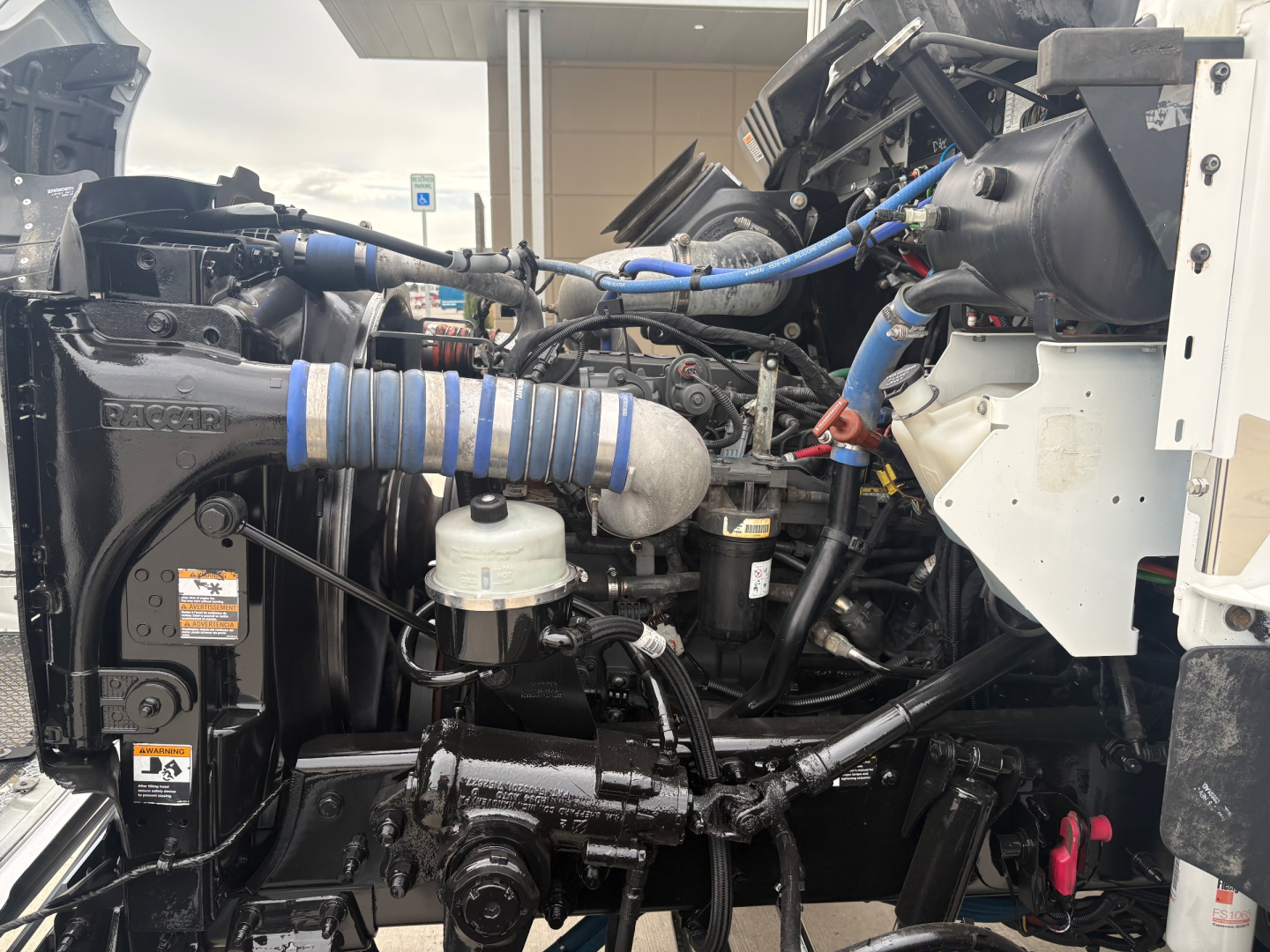 Kenworth T270 engine bay with visible hoses, wiring, and components including air intake and fluid reservoirs.