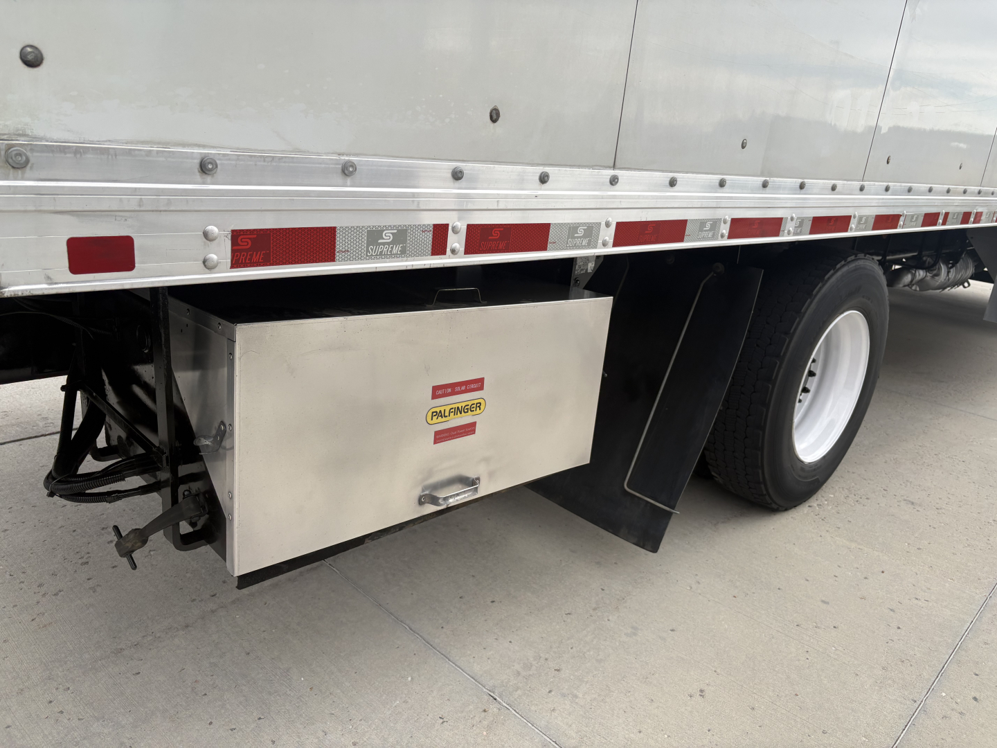 Truck side view showing aluminum toolbox mounted under the cargo bed of a 2020 Kenworth T270 with box body, rear dual wheels, reflective tape, and stock number 0630677.