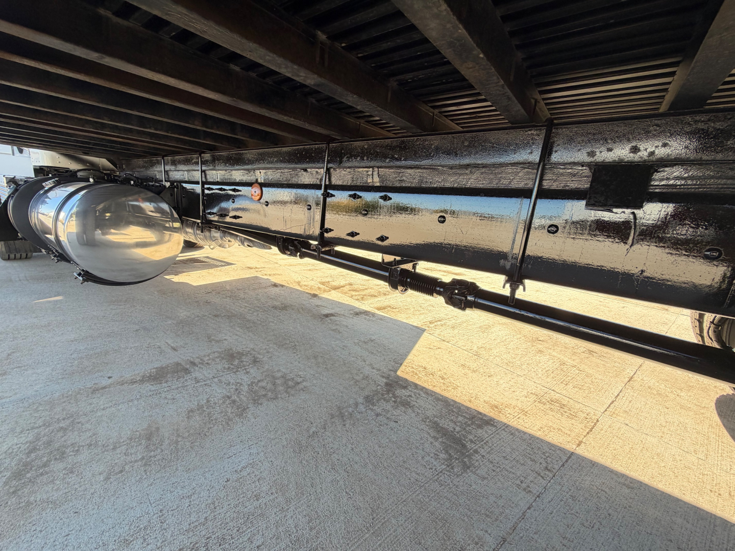 Underbody view of a 2020 Kenworth T270 truck showing a large cylindrical fuel tank or air tank and frame rails with wiring and piping along the underside.