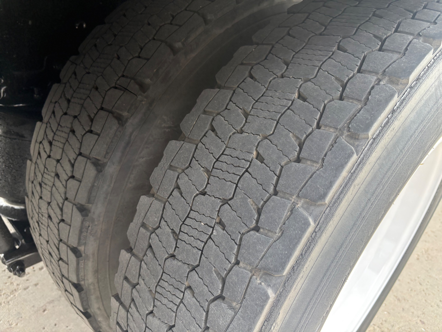 Kenworth truck wheel and tire tread close-up showing heavy-duty off-road style tread.