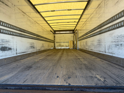 Kenworth truck box interior showing empty cargo area with ribbed metal floor and side rails.