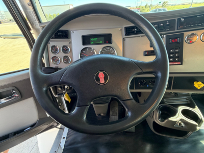 Dashboard and steering wheel of a Kenworth T270 truck showing instrument gauges, steering wheel with Kenworth emblem, ignition with key, and dashboard panels.