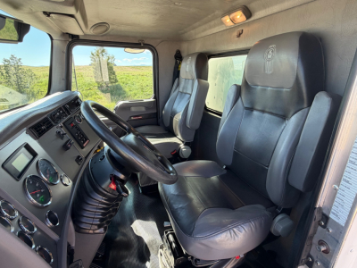 Interior of a Kenworth T270 cab showing steering wheel, dashboard gauges, and two black leather seats.