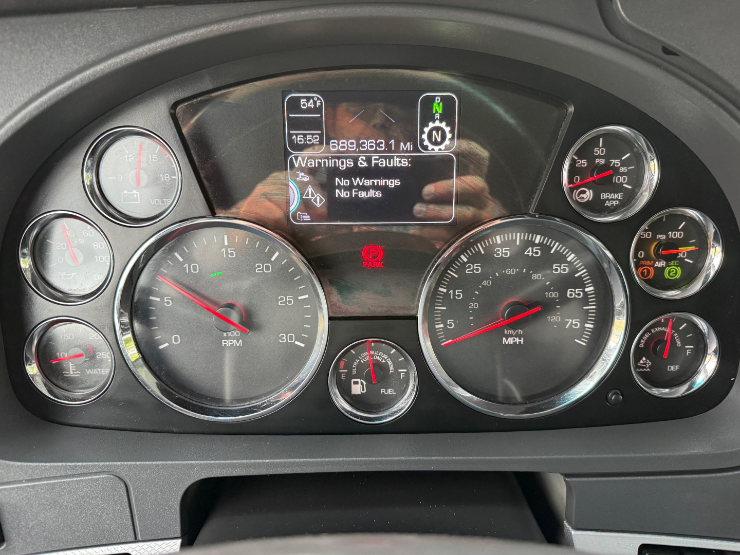 Kenworth T680 dashboard showing digital display with engine RPM gauges and surrounding analog gauges.