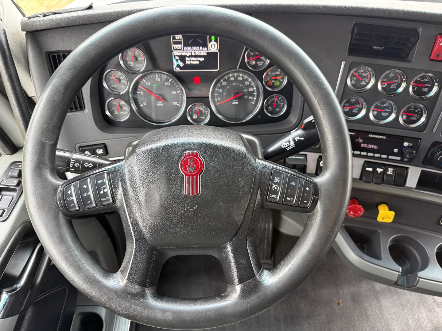 Kenworth T680 dashboard and steering wheel view showing gauges and controls.