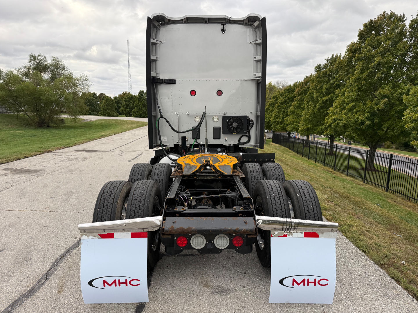 Kenworth T680 rear view showing dual rear axles and mud flaps with MHC logos