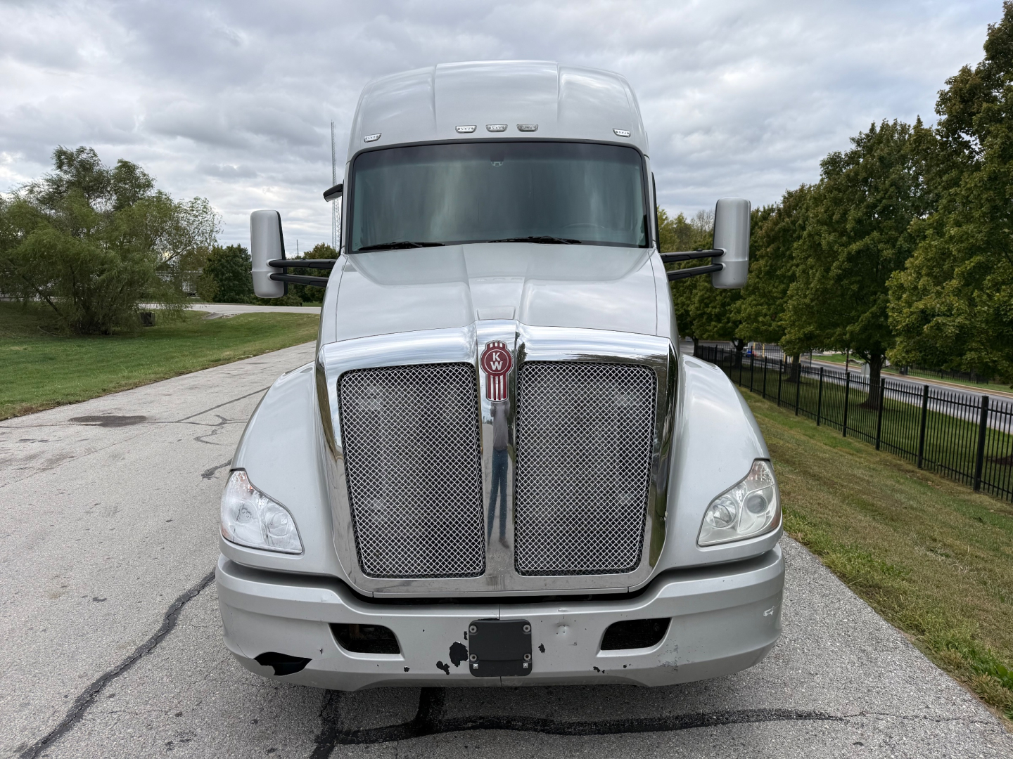 Kenworth T680 front view showing chrome mesh grille and headlights, silver exterior, no visible text.
