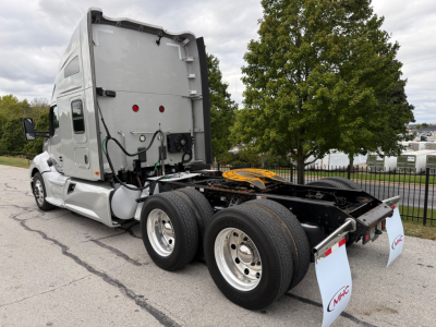 Kenworth T680 tractor cab with rear view showing fifth wheel and dual rear axles, side exhaust, gray exterior, back of sleeper, VIN/stock not visible in text on image.
