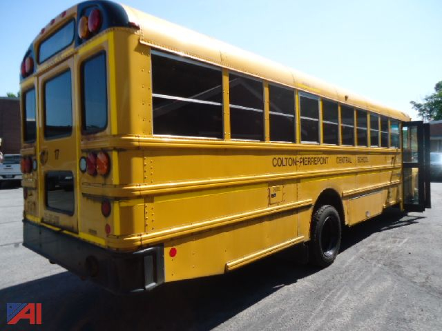 Yellow IC Corporation CE series school bus with black trim and rear doors, side lettering Colton-Perkson Central California, bus body view from rear-left.