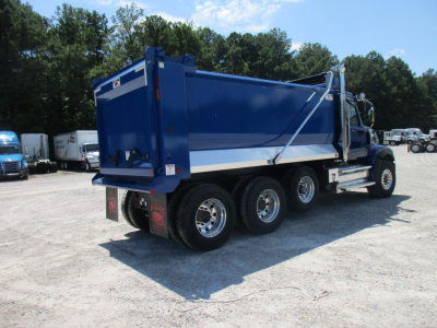 Western Star 49X dump truck in blue with white stripe, side view showing 6-wheel tandem rear, dumping bed, front cab, and chrome wheels.