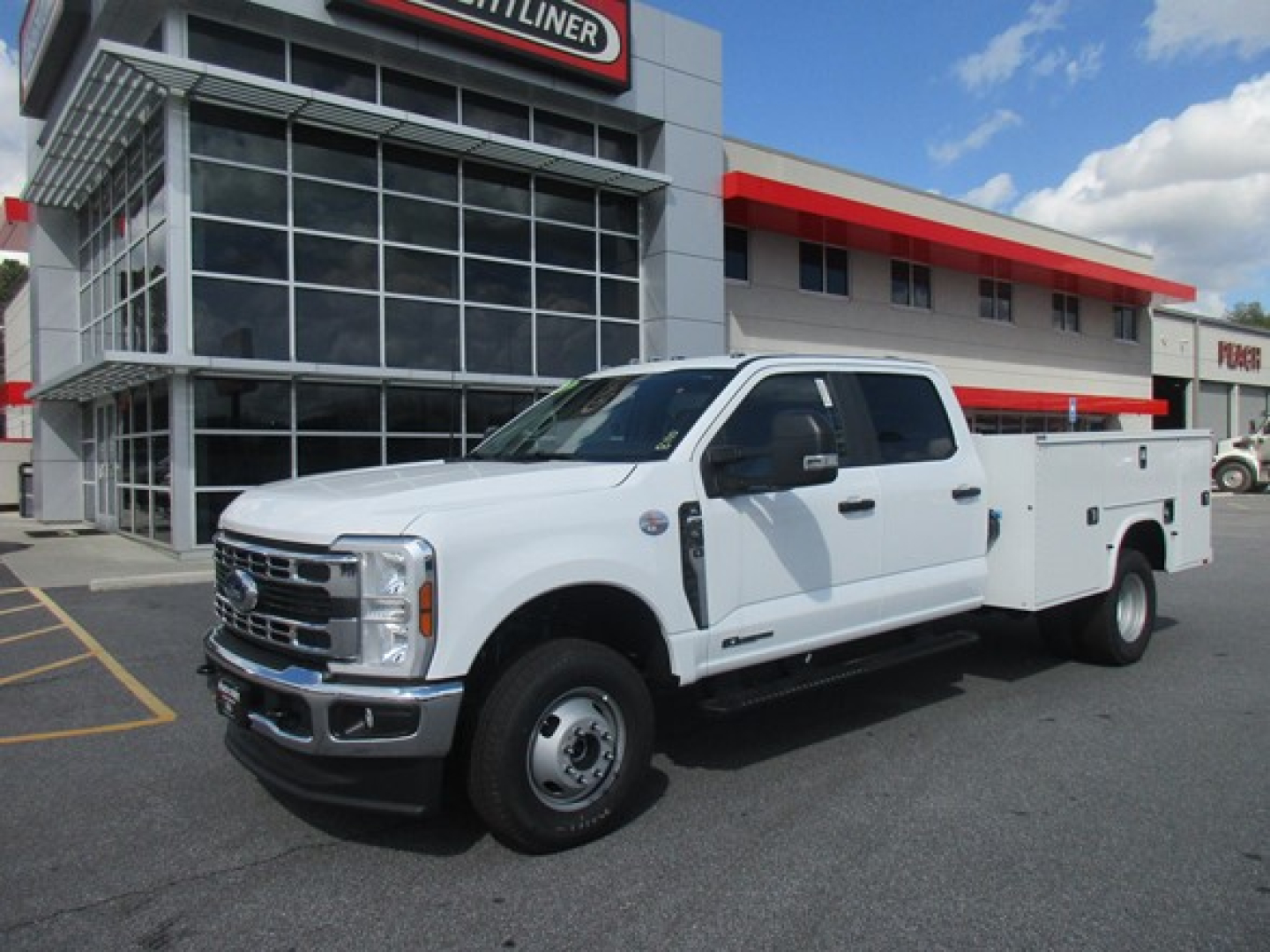 Ford F-350 service/utility truck in white, dual rear wheels, utility bed, front grille and headlights visible.
