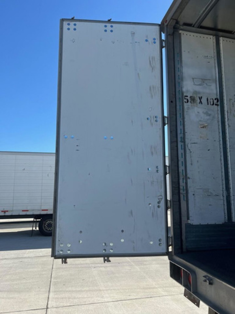 Truck trailer rear doors and interior of a 2012 utility van showing open cargo area and metal paneling.