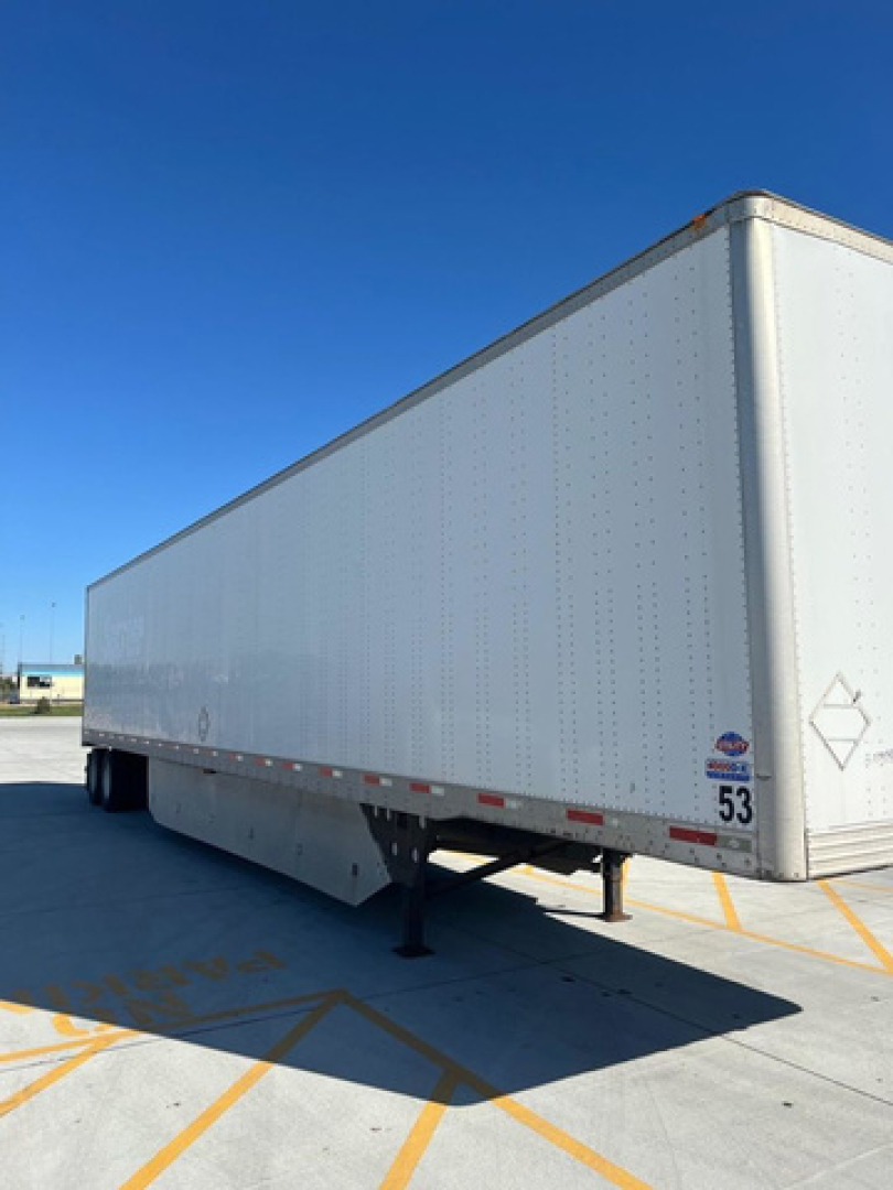 Utility trailer van showing side and front corner with support legs extended.