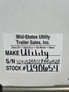 Trailer tag showing Mid-States Utility Trailer Sales, Inc. with S/N and STOCK numbers on a utility trailer.