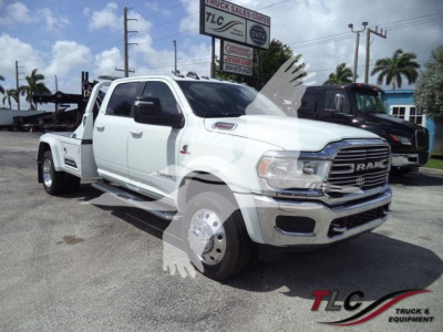 Ram 5500 Laramie pickup truck in white, front-angle view with winch category sign in background.