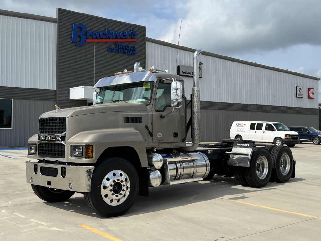 Mack PI64T truck in serviceable condition parked in lot with Brueckner's Truck Equipment building in background.
