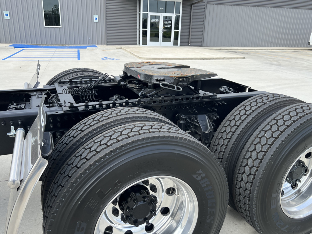 Mack PI64T truck chassis showing rear dual rear axles with dual tires and fifth-wheel mounting plate.