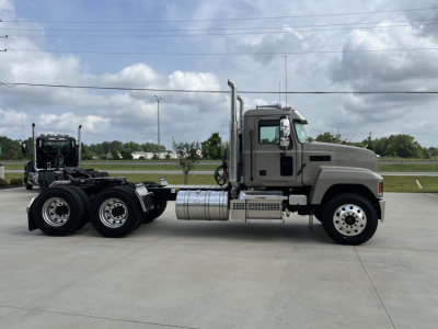 Truck side view showing a 2027 Mack PI64T conventional daycab with dual rear axles and a silver fuel tank. No visible text on the cab or chassis.
