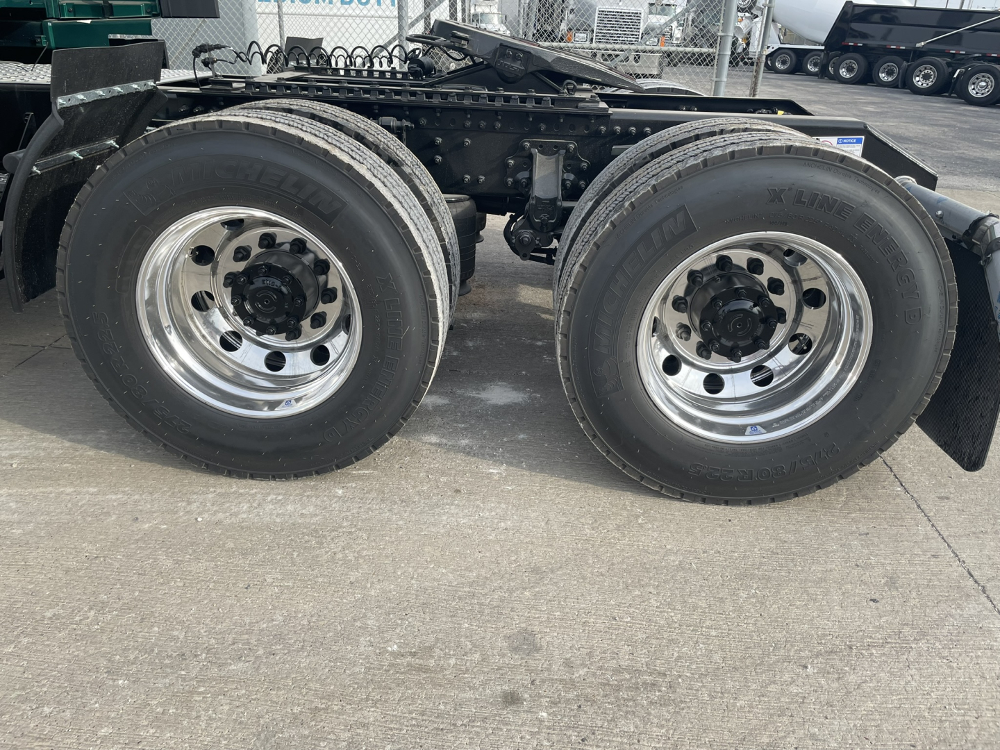 Dual rear tractor axles and tires on a new Volvo VNL64T860 tractor chassis showing chrome wheels and rubber tires.
